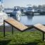 Saint-Tropez Deck Chair painduva puidust istumispinnaga ja mustast metallist raamiga, paigutatud mur