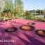 Round trampoline (100 cm) paigaldatud punasele pehmele pinnale mänguväljakul.
