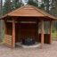 Wooden Wall to Gazebo Shelter puidust paviljon metsas, ümarate postidega ja kivikamina keskel