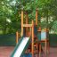 Tower with Slide laste mänguväljakul, puidust ja metallist liuguriga.