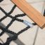 Double Hammock (Metal) mustade köite ja puidust raamiga laste mänguväljakul.