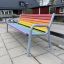 Colourful bench laste mänguväljakul mitmevärvilise istme ja hallide metallraamidega.
