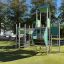 Fort with two towers and a slide laste mänguväljak metallraamide ja roheliste paneelidega.