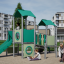Tower playhouse with a slide lastetuba tänavapargis mängivate lastega.