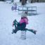 Bird swing mänguväljakul talvesel ajal, laps riides soojalt mängib.