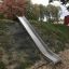 Nature Hill Slide STS210 metallist liug, paigaldatud halja mäenõlva servale laste mänguväljakul.